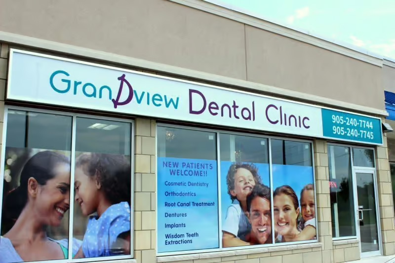 The image shows a storefront sign for  Grandview Dental Clinic,  with a photograph of a family on the window display, indicating a welcoming and family-oriented environment.