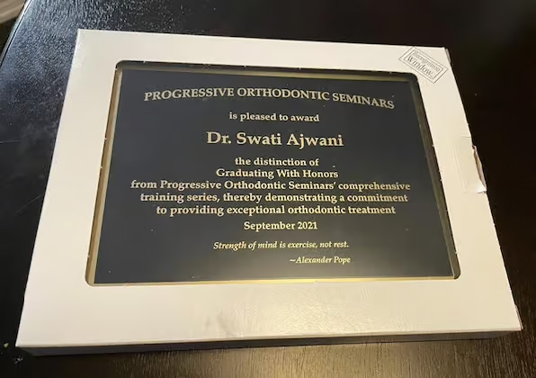 The image shows a framed plaque with text and an award, placed on a surface.