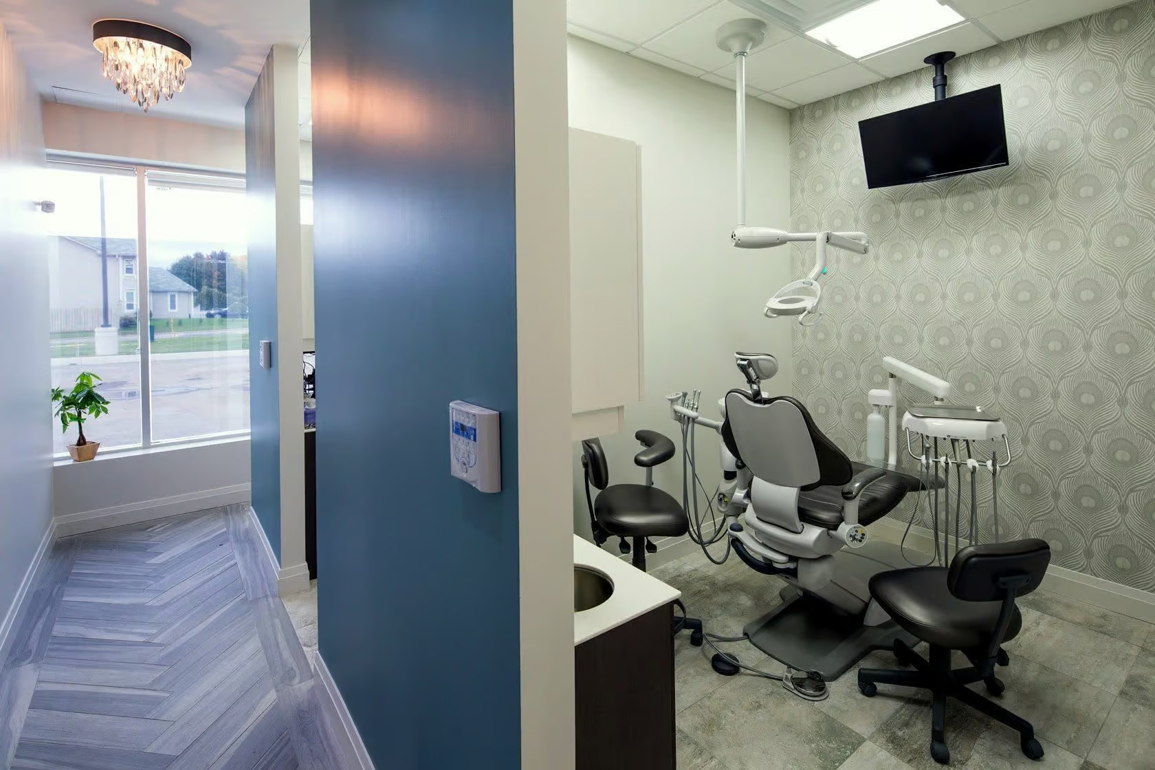 The image shows a modern dental office interior with various pieces of equipment and furniture typically found in such a setting.