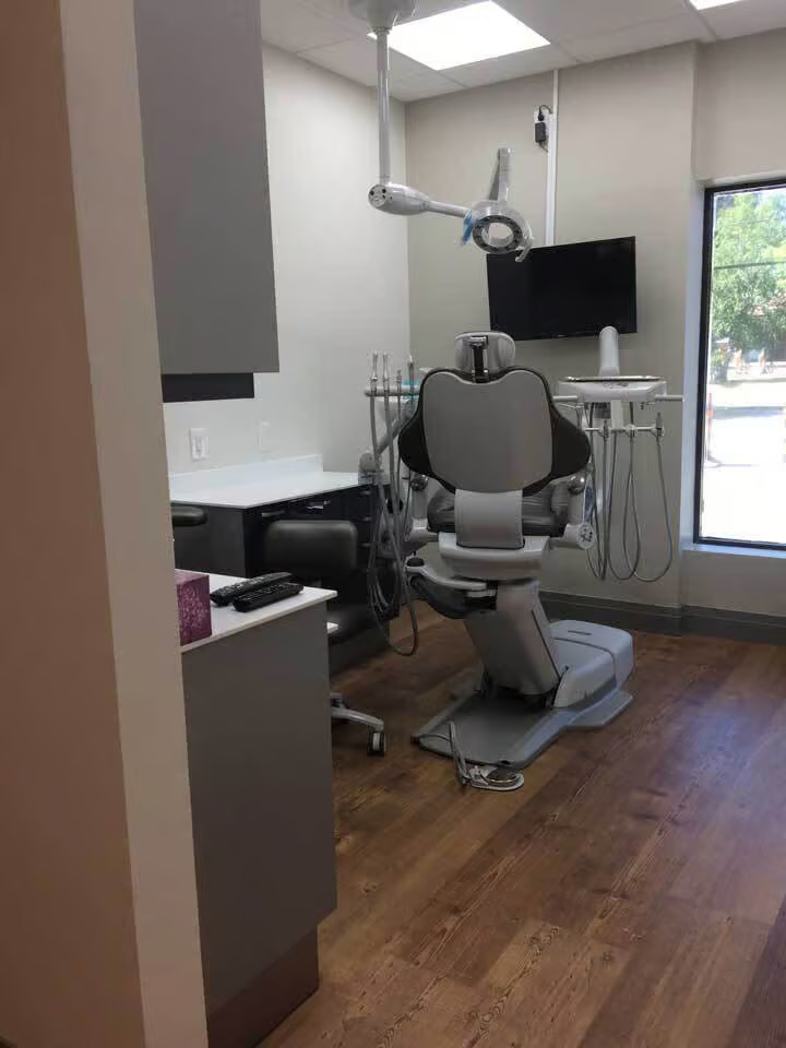 Dental office interior with dental chair and equipment, featuring a modern design and clean environment.